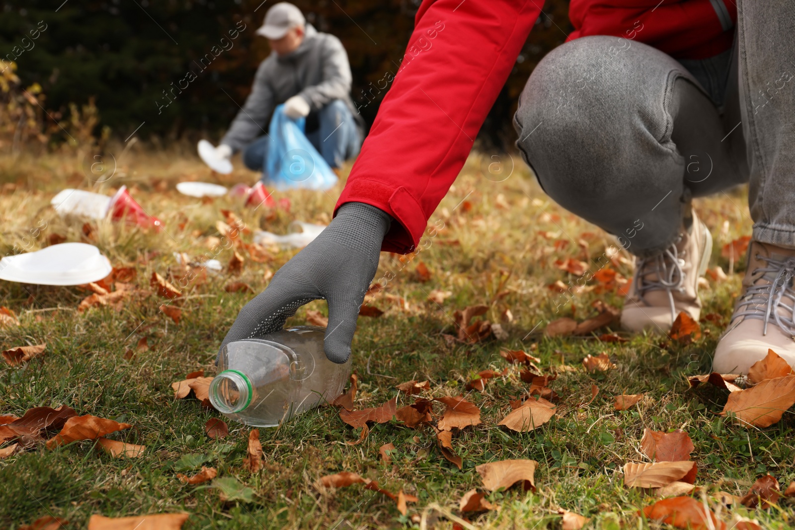 Photo of People collecting garbage in nature, closeup of hand with bottle