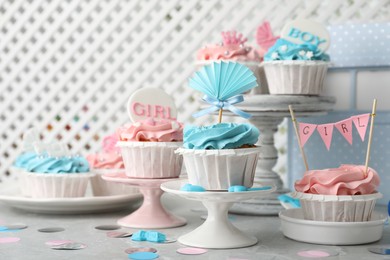 Photo of Delicious cupcakes with light blue and pink cream for baby shower on grey table