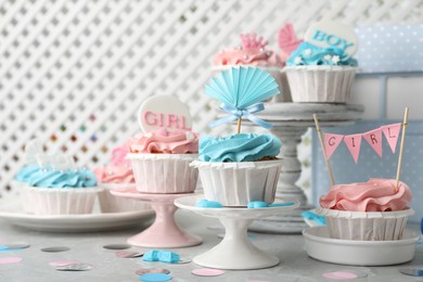 Delicious cupcakes with light blue and pink cream for baby shower on grey table