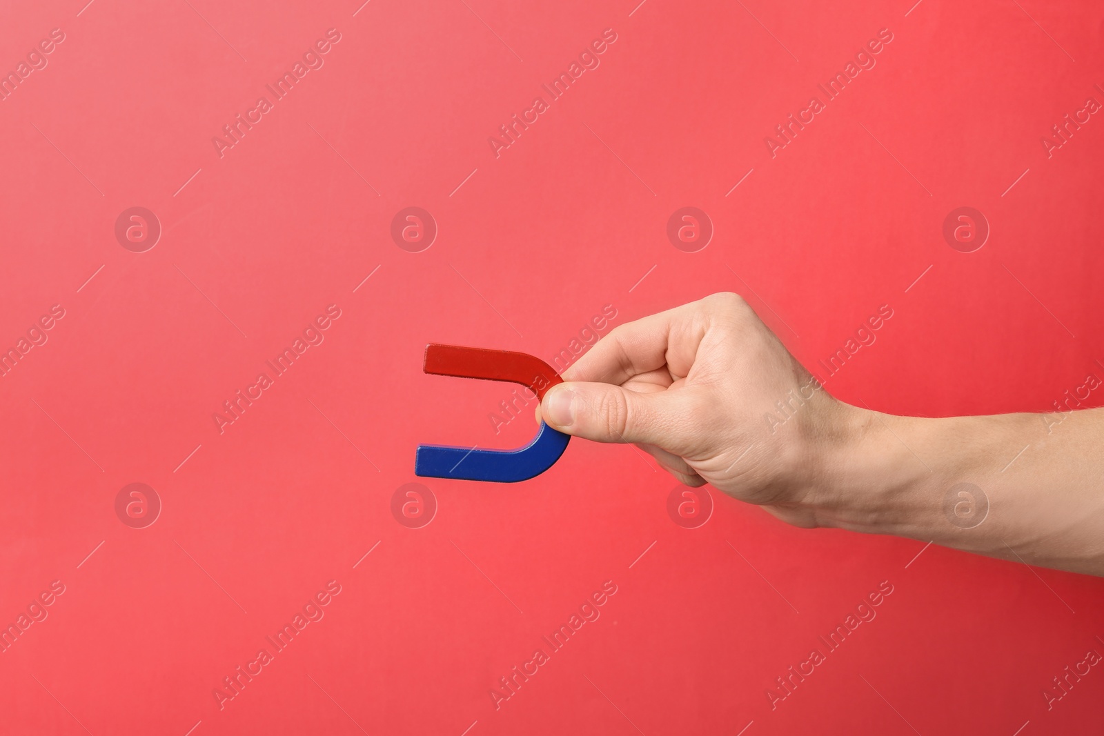 Photo of Man holding magnet on color background, closeup. Space for text