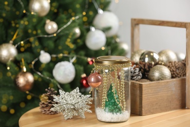 Handmade snow globe and Christmas decorations on wooden table