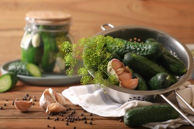 Photo of Fresh cucumbers, dill, peppercorns and garlic on wooden table. Pickling recipe