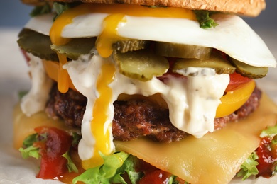 Closeup view of tasty burger with fried egg