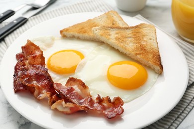 Photo of Delicious breakfast with sunny side up eggs on white marble table, closeup