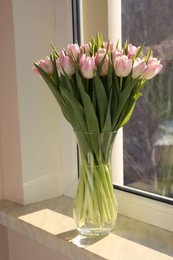 Photo of Spring is coming. Bouquet of beautiful tulip flowers in glass vase on windowsill indoors