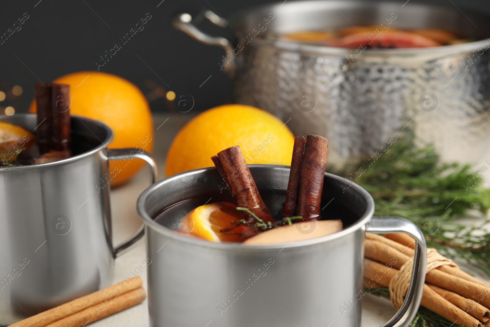 Photo of Tasty mulled wine with spices in mug on table