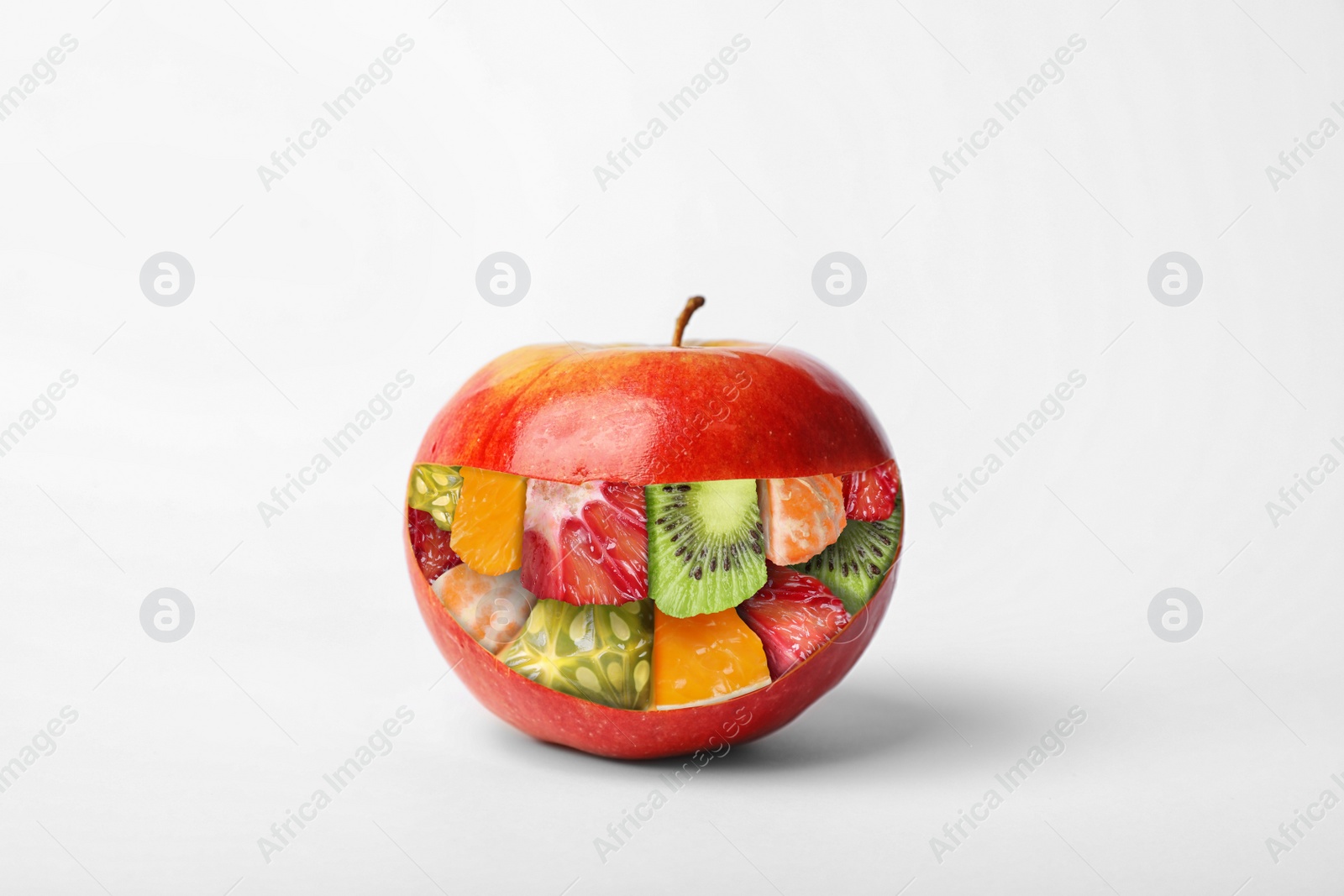 Image of GMO concept. Fresh ripe apple and pieces of different fruits inside of it