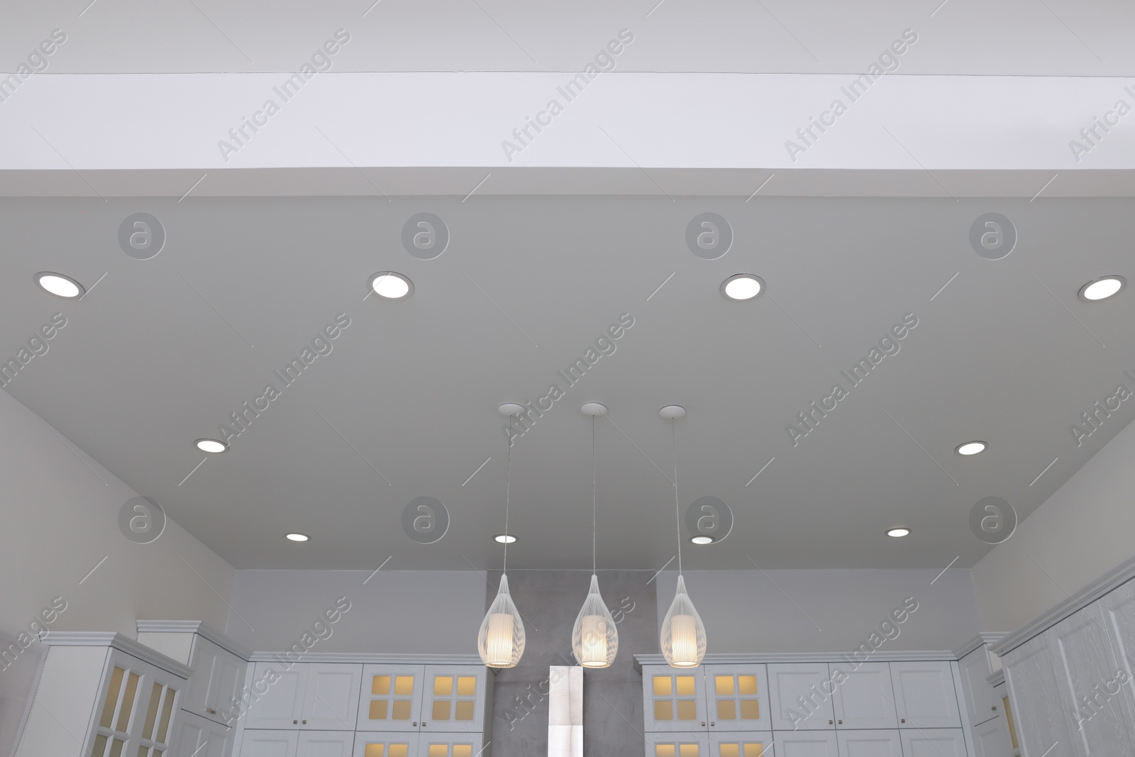 Photo of Ceiling with modern lamps and furniture in stylish kitchen, low angle view