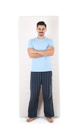 Young man with comfortable mattress isolated on white