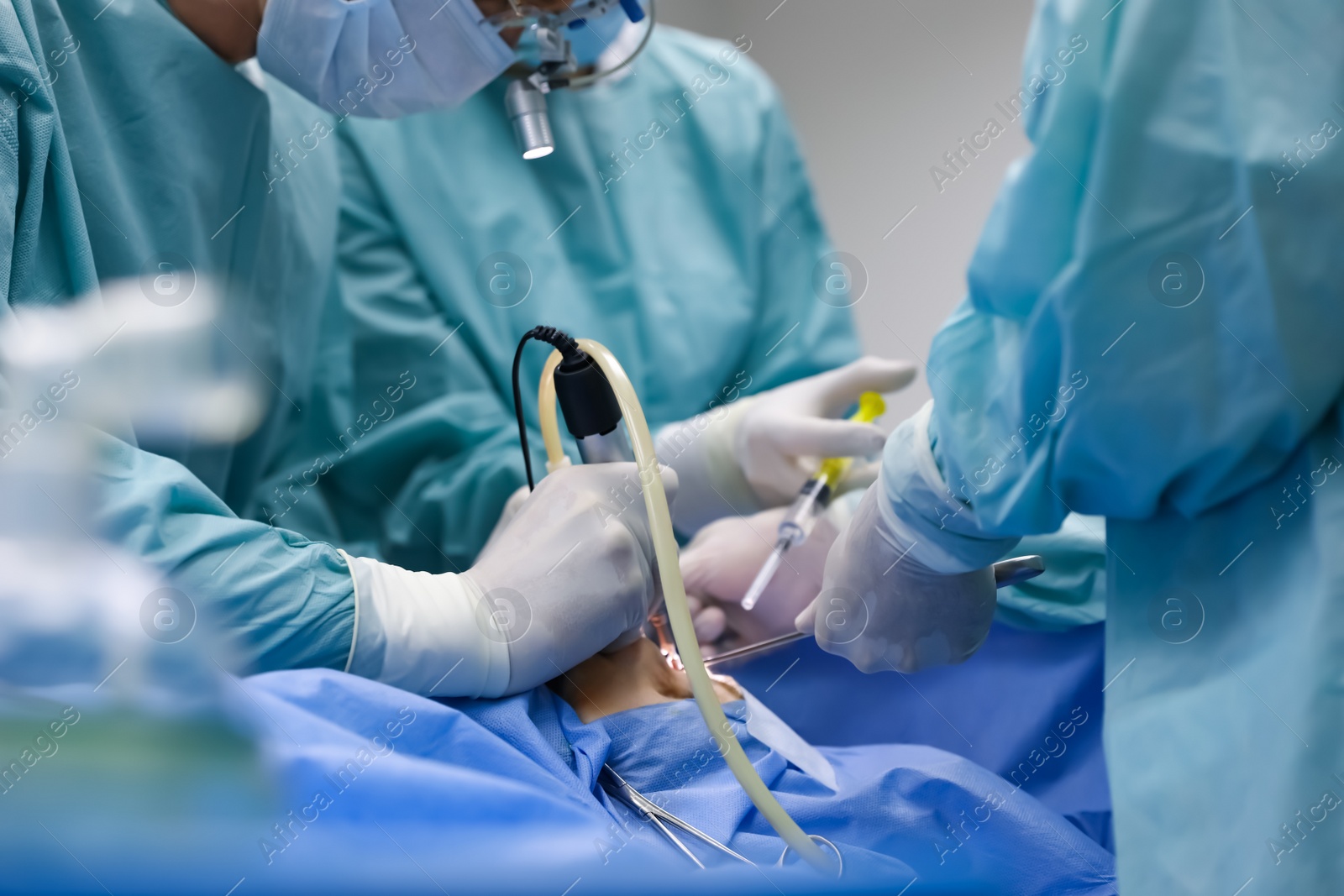 Photo of Professional doctors performing 
frontal sinus trephination in surgery room, closeup