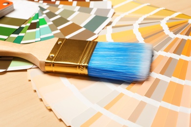 Paint brush and color palettes on table, closeup