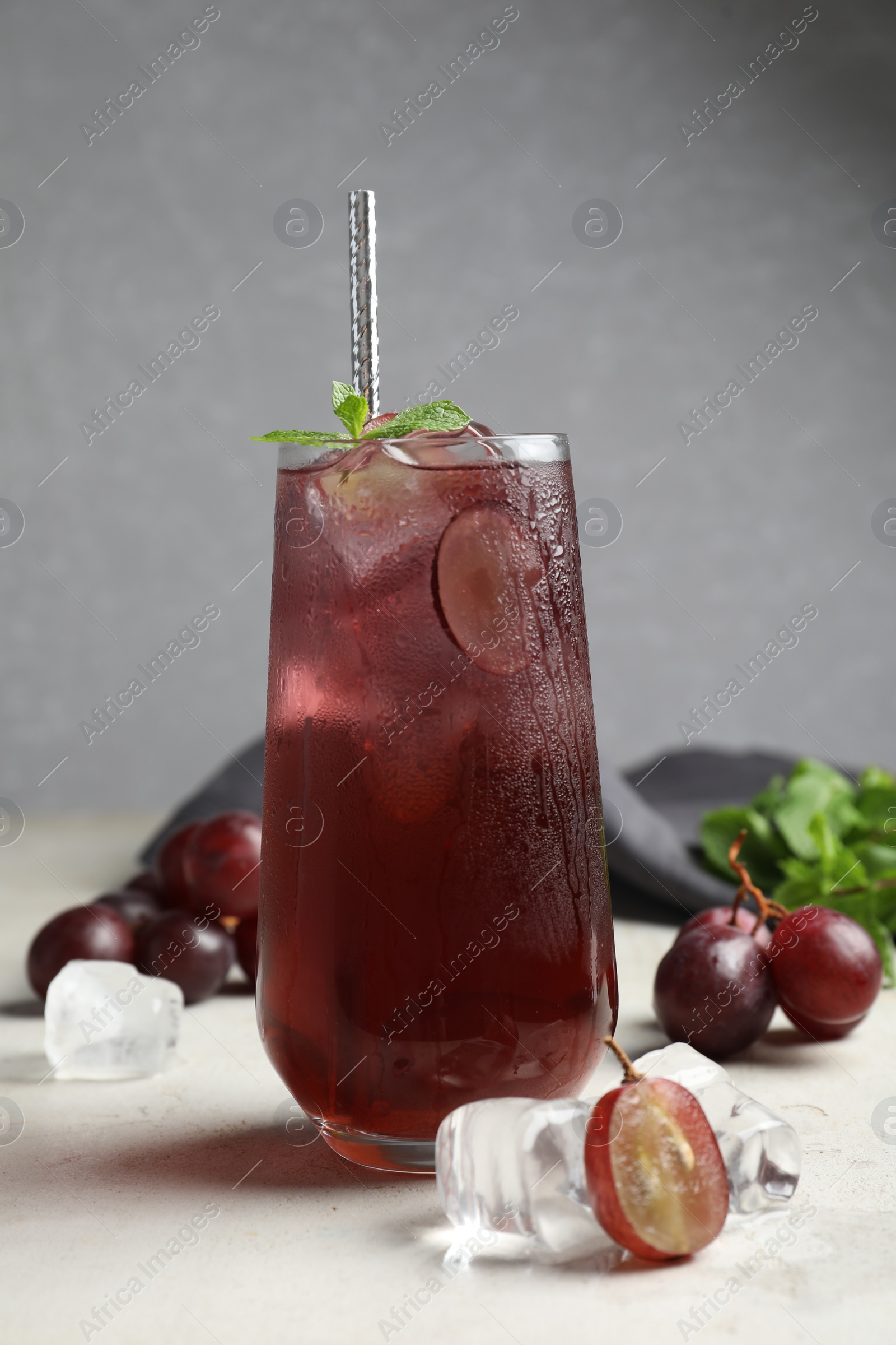 Photo of Delicious grape soda water with mint on white table. Refreshing drink