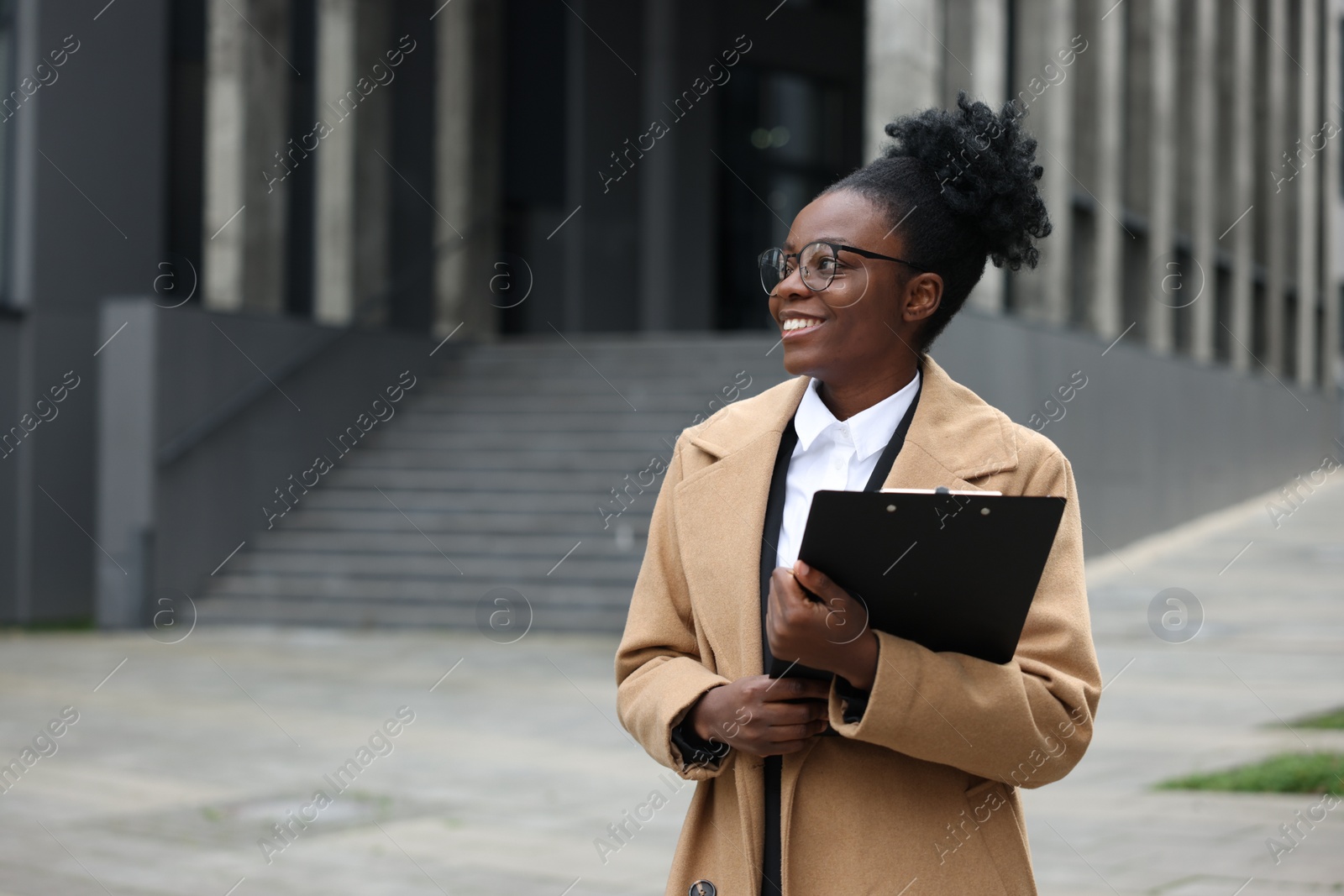 Photo of Happy woman with clipboard outdoors, space for text. Lawyer, businesswoman, accountant or manager