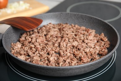 Photo of Frying minced meat in pan on induction stove, closeup