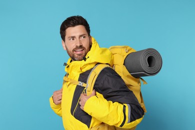 Photo of Happy tourist with backpack on light blue background