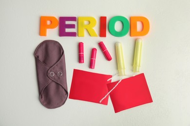 Photo of Tampons and other period products on white background, flat lay