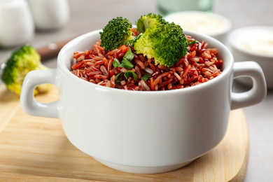 Tasty brown rice with broccoli on table, closeup