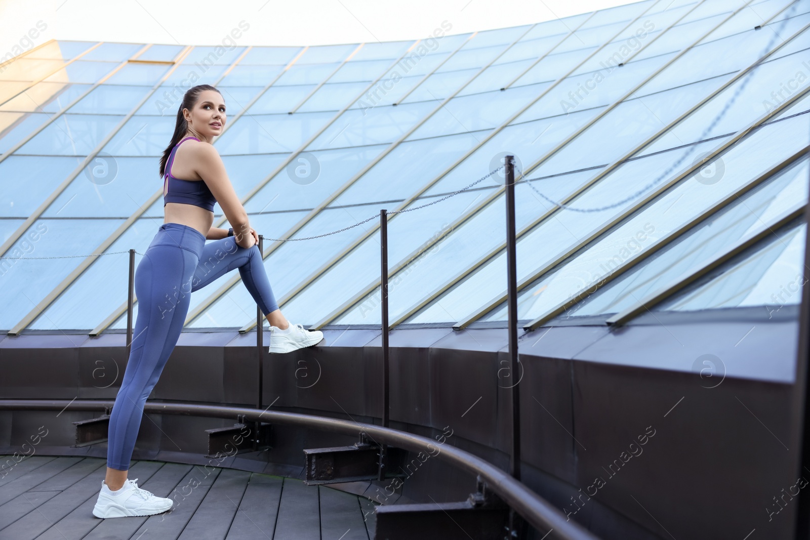 Photo of Beautiful woman in stylish sportswear doing exercises outdoors