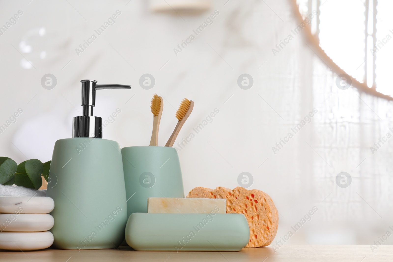 Image of Bath accessories. Different personal care products and eucalyptus leaves on wooden table in bathroom, space for text