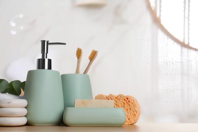 Bath accessories. Different personal care products and eucalyptus leaves on wooden table in bathroom, space for text