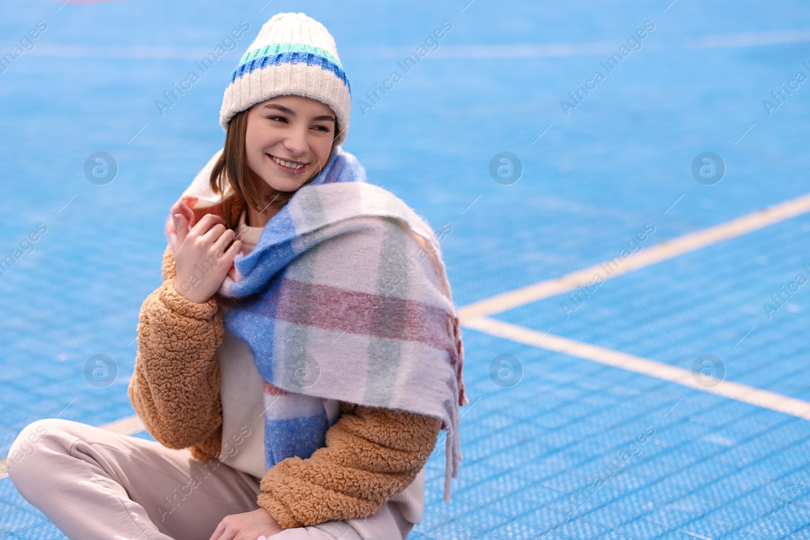 Photo of Beautiful woman in warm scarf and hat outdoors, space for text