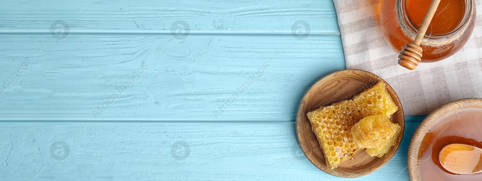 Image of Flat lay composition with delicious honey on blue wooden table, space for text. Banner design