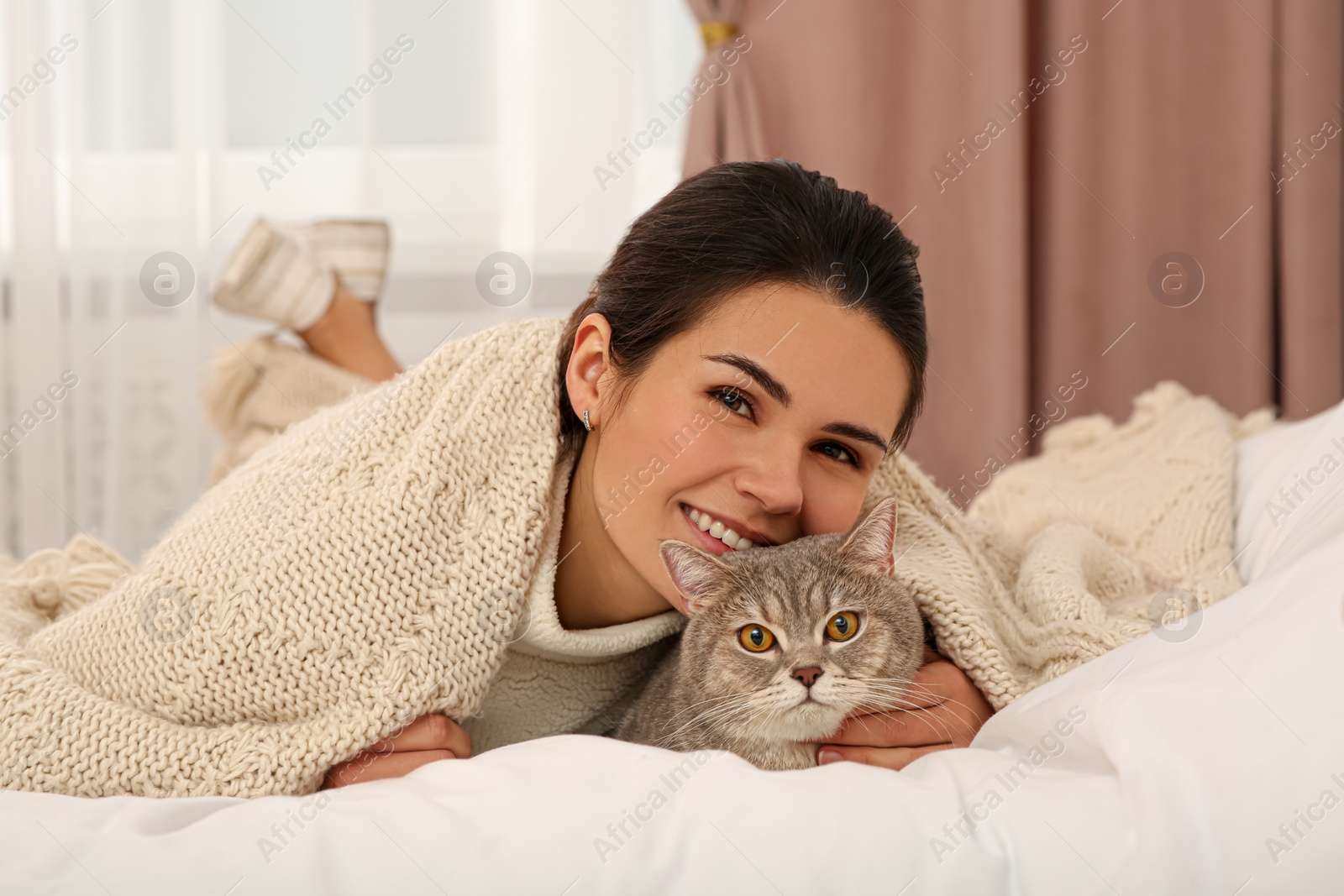 Photo of Young woman with adorable cat at home