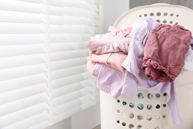 Photo of Laundry basket with baby clothes indoors. Space for text