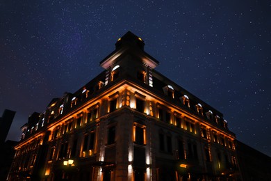 Photo of Exterior of beautiful illuminated building on starry night, low angle view