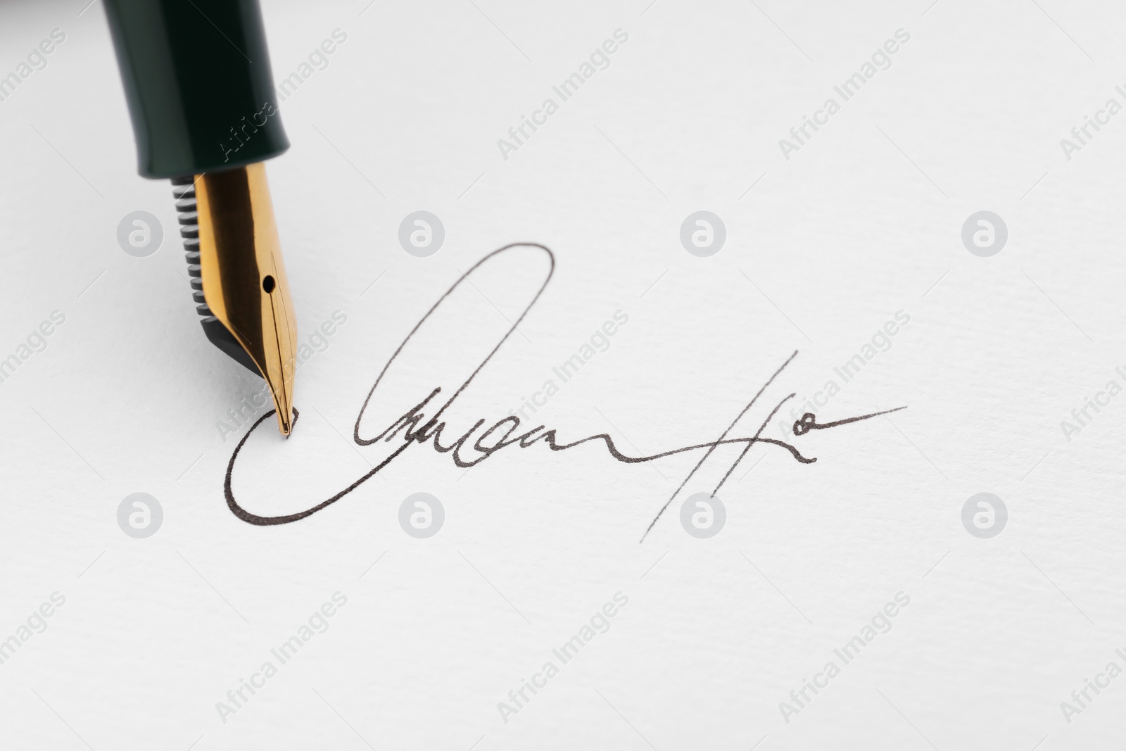 Photo of Signing on sheet of paper with fountain pen, closeup