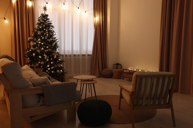 Photo of Tv area with cabinet, comfortable sofa, armchair and coffee table near Christmas tree in room