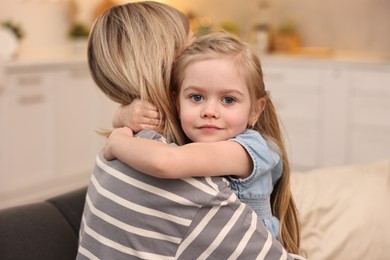 Cute little girl hugging her mom at home. Happy Mother's Day