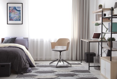 Photo of Modern teenager's room interior with workplace and bed