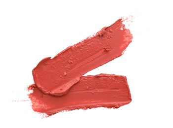 Photo of Smears of coral lipstick on white background