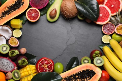 Frame of different exotic fruits on black background, flat lay. Space for text