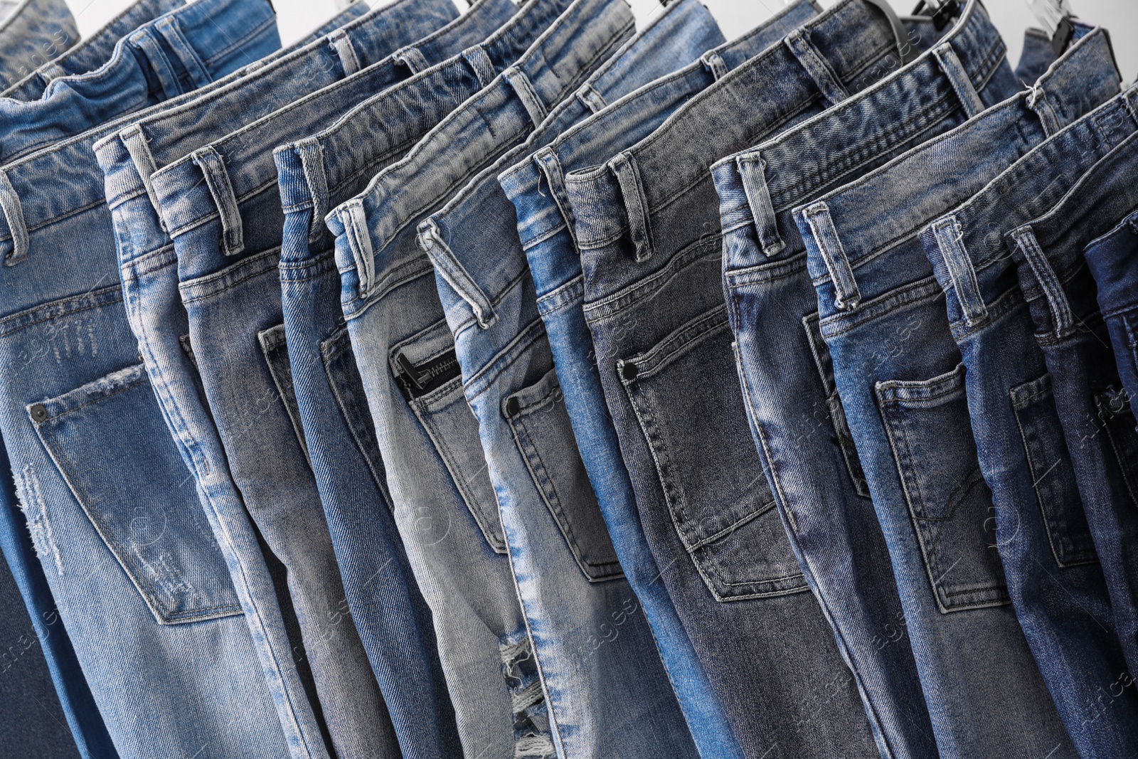 Photo of Closeup view of rack with different jeans