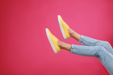 Woman in stylish sport shoes on pink background. Space for text