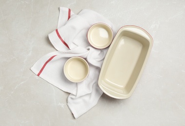 Baking dishes on grey table, flat lay. Cooking utensils