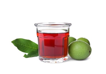 Photo of Delicious liqueur and green walnuts on white background