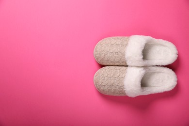 Photo of Pair of beautiful soft slippers on pink background, top view. Space for text