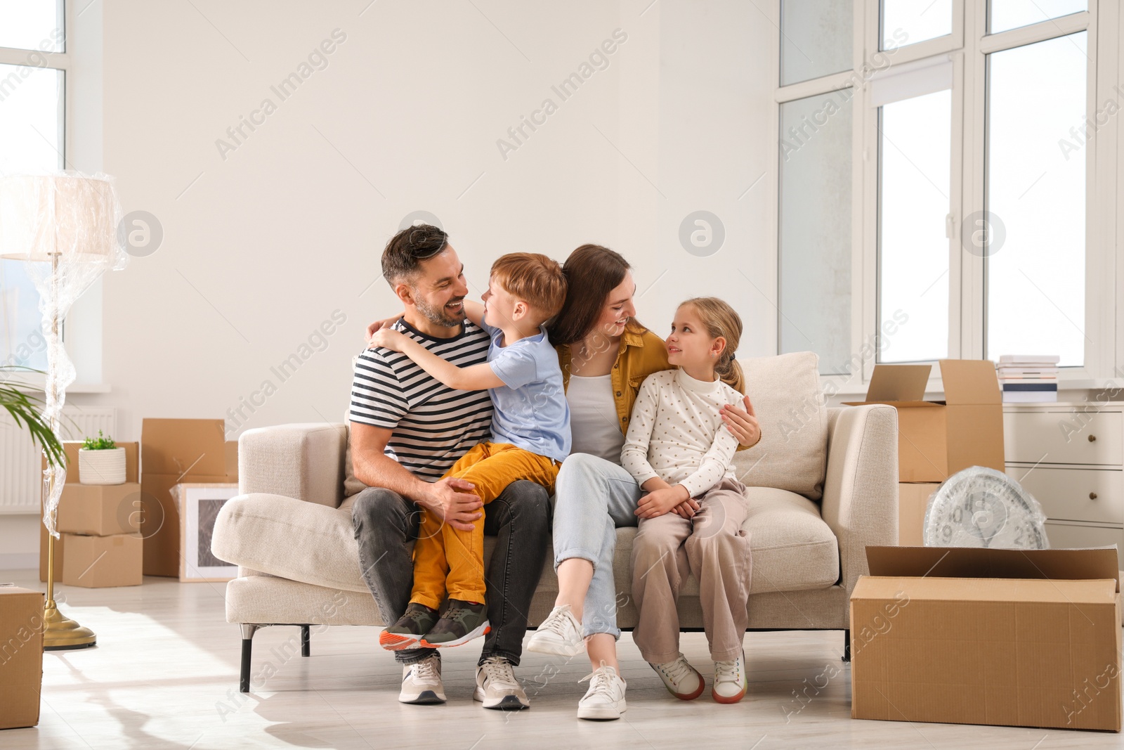 Photo of Happy family sitting on couch in new apartment. Moving day