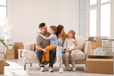 Happy family sitting on couch in new apartment. Moving day