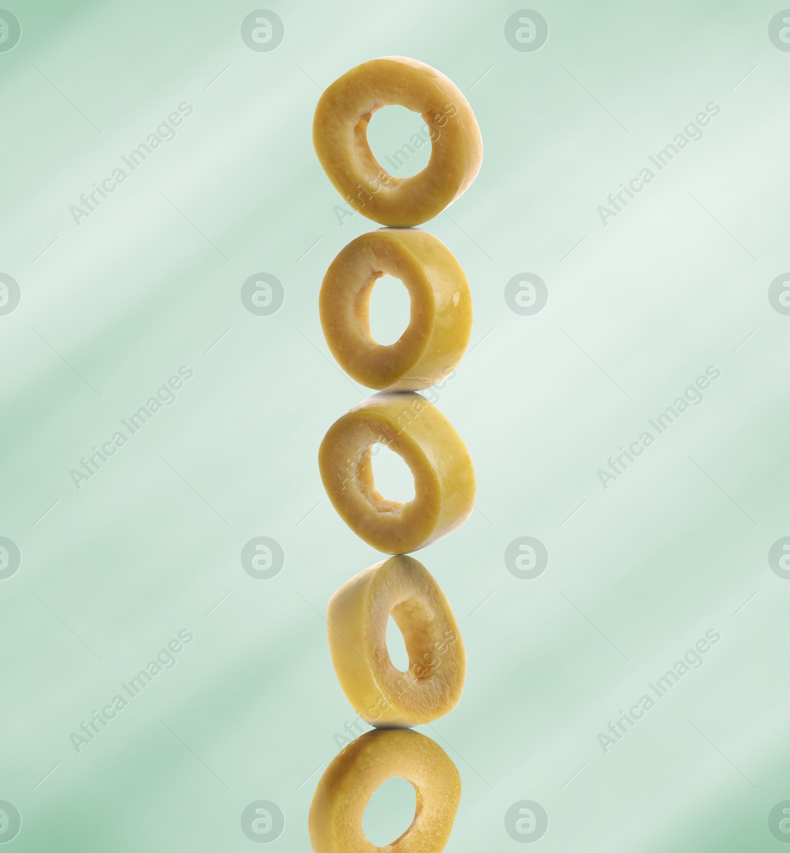 Image of Stacked slices of olive on light green gradient background