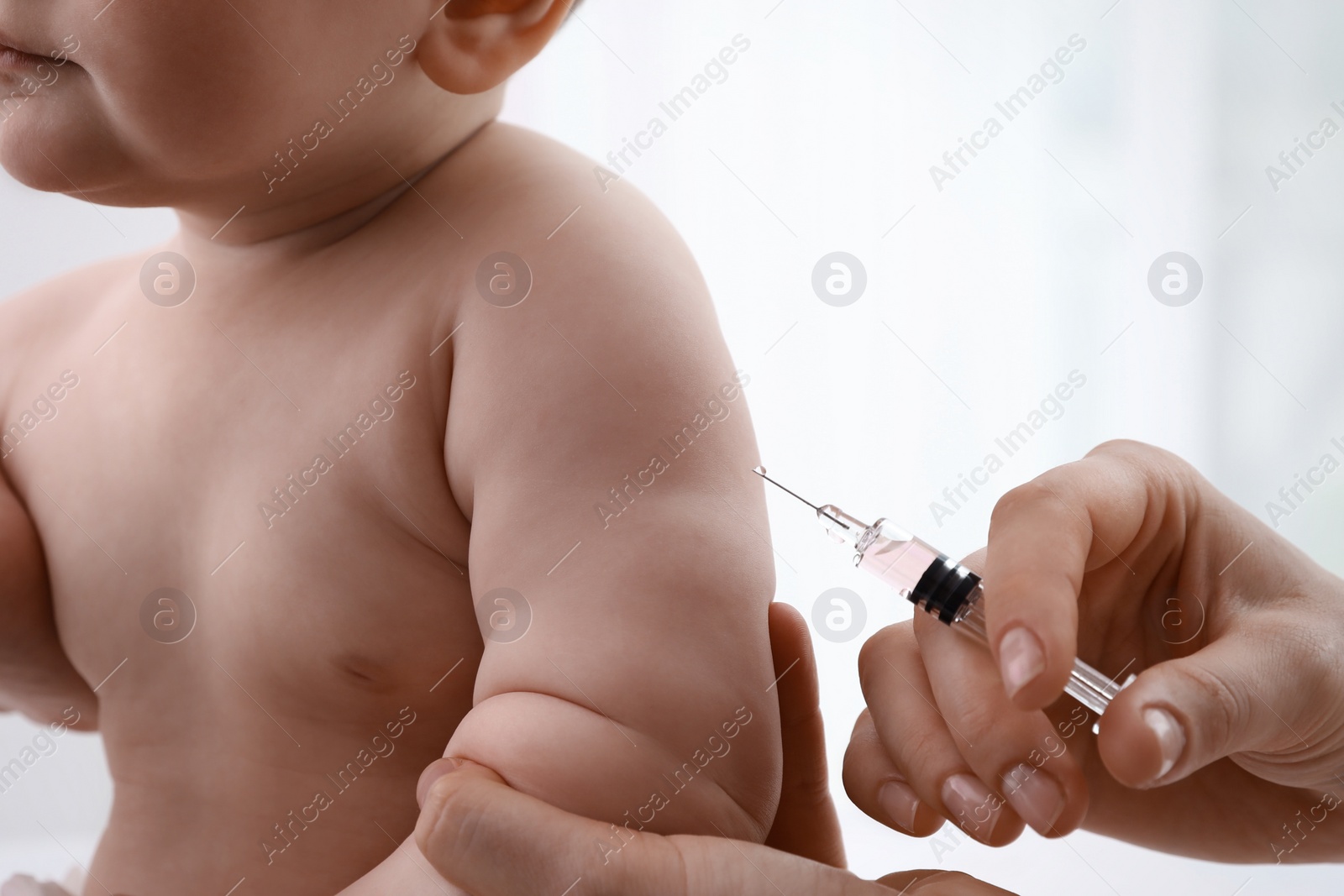 Photo of Doctor vaccinating baby against light background, closeup. Health care