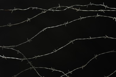 Photo of Shiny metal barbed wire on black background