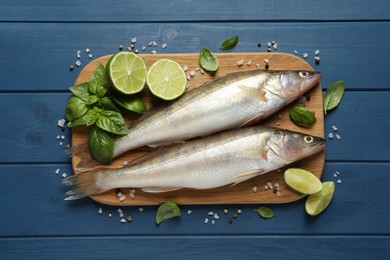 Photo of Fresh raw pike perches and ingredients on blue wooden table, flat lay. River fish