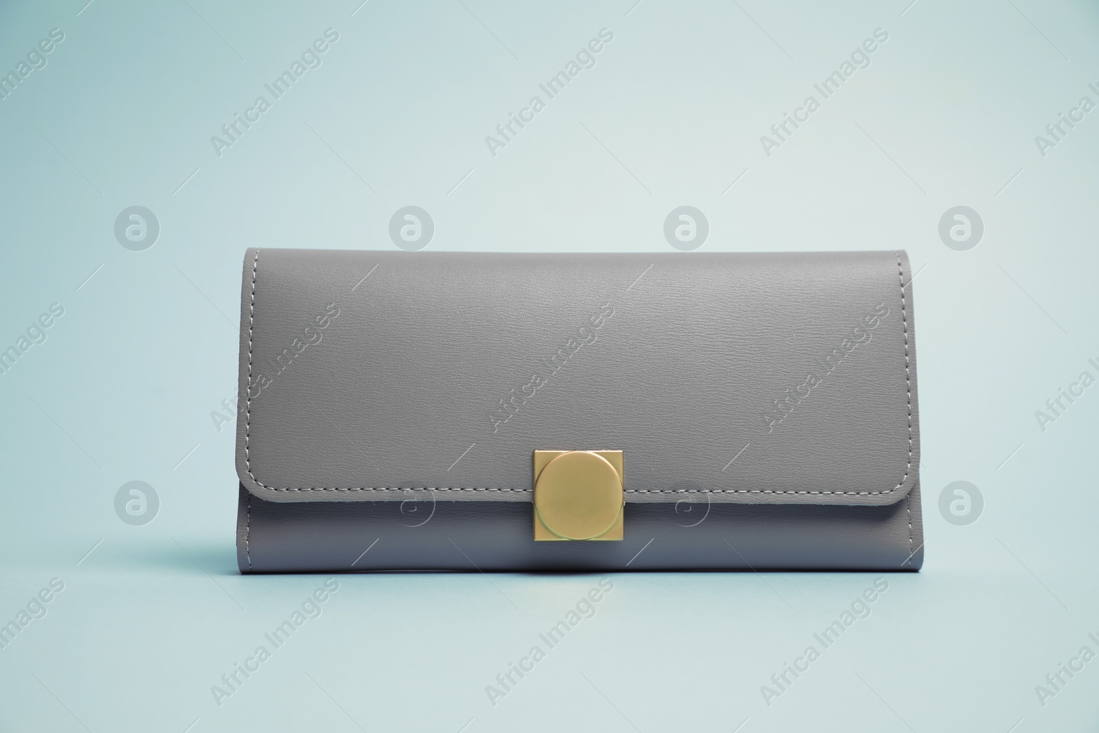 Photo of Stylish leather purse on light blue background