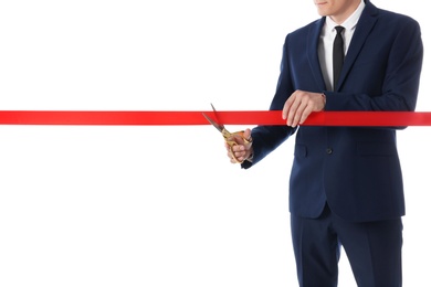 Man in office suit cutting red ribbon isolated on white, closeup