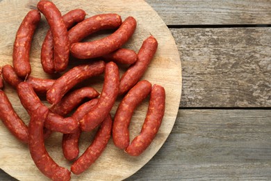 Photo of Delicious sausages on wooden table, top view. Space for text