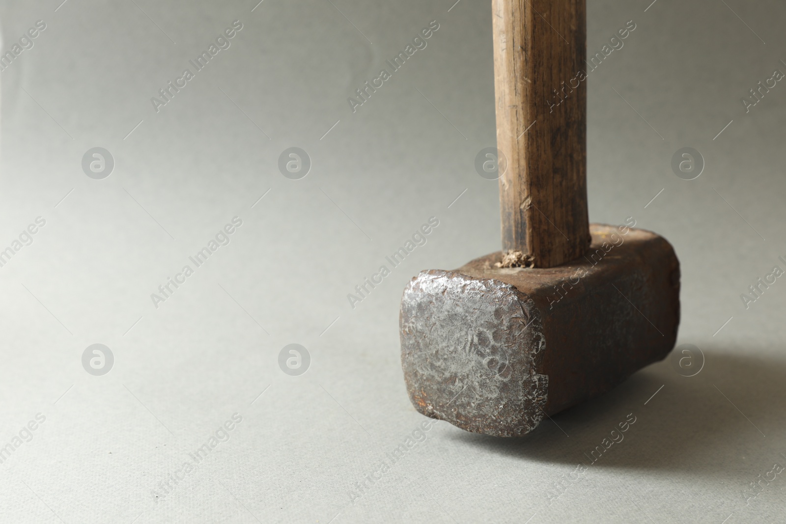 Photo of One sledgehammer on grey background, closeup. Space for text